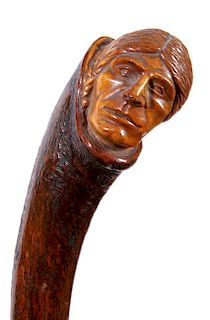 302. Native American Folk-Art Cane – Ca. 1900 – A carved one-piece bark shaft which has a detailed carving of a Native Am