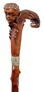 353. Classical Folk-Art Cane – Ca. 1900 – A carved one-piece handle with a child’s head and a pair of wings, ornately c