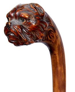 375. Folk-Art Dog Cane – Ca. 1890 – A carved one-piece burl hardwood branch cane with a long-haired pug-nosed terrier of