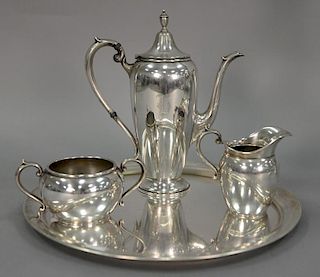 Sterling silver four piece tea set to include a round tray (dia. 12in.), creamer, sugar, and teapot (ht. 8 1/2in.), monogramm