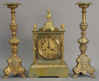 Three piece lot to include a brass and alabaster mantle clock (ht. 14 1/2in.) and a pair of baroque style heavy brass pricket
