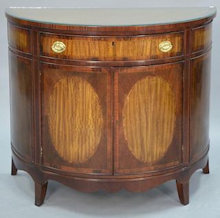 Heritage half round side cabinet, banded inlaid mahogany having one drawer over double doors and fitted glass top. ht. 35in.,
