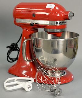 Red KitchenAid artisan mixer with attachments.