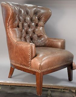 Contemporary leather barrel back wing chair with tufted back.