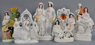 Five Staffordshire figural pieces two clock cases, one hand painted cow spill vase, a double figure sitting on a clock, and "