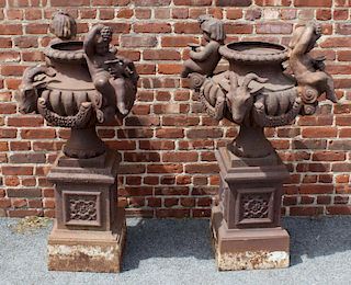 A Pair of Cast Iron Figural Urns on Stands.