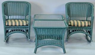 Green wicker style four piece group to include two rocking chairs and two glass top table.