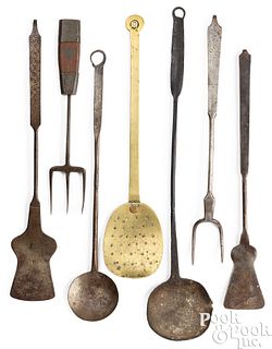 Seven wrought iron and brass kitchen utensils