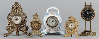 Four brass desk clocks, together with a porcelain clock, tallest - 10''.