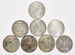 Eight silver dollars, to include three Morgan and five Peace.