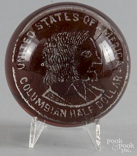White frit paperweight on a deep amber ground, depicting the Columbian half - dollar, 3 1/2'' dia.