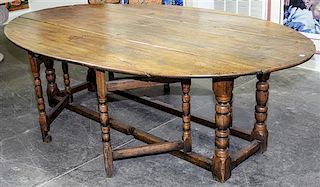 A Large Oak Gate-Leg Dining Table Height 28 1/2 x width 91 x depth 21 1/2 inches.