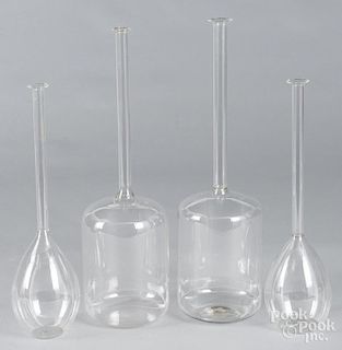 Four colorless glass thin neck bottles