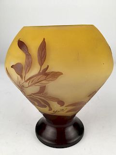 Galle cameo vase with dark and light brown leaves on a ellow ground.