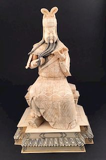 LARGE CARVED BONE MAN READING A BOOK.