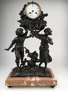 White metal decorative clock with plate reading "Les Vendanges Par Francois More