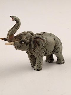 A small Vienna bronze elephant with their tusk up.