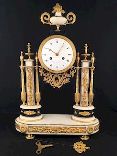 Marble and gold dore bronze clock.<BR>Supported on four tublar feet.<BR>The top fini