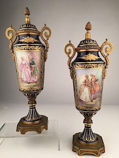 Pair of Sevres urns with gold dore bronze handles and base.