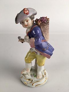 Meissen figure of a young boy with a sickle and a basket of grapes.<BR>Marked with