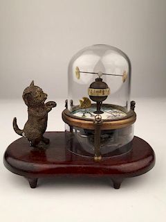 A novelty clock with a kitten looking at a fish tank.