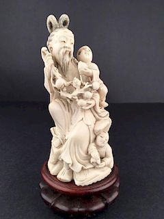 Antique carving of a father with a long beard with two young children near him