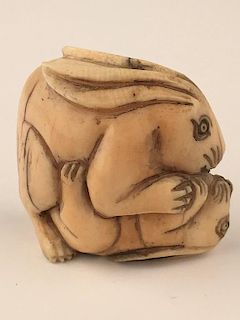 A carved Netsuke figure of two rabitts playing.