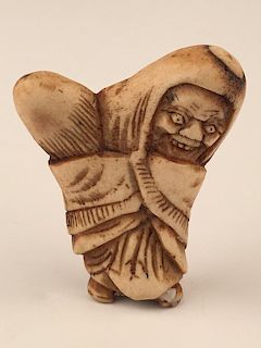 A carved Netsuke figure of a man holding crops.