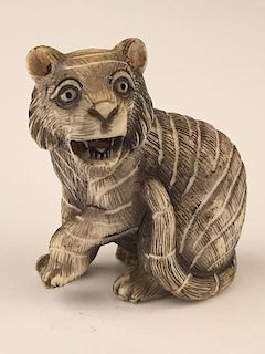 A carved Netsuke figure of a sitting lion.