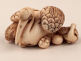 A carved Netsuke figure of a large swan and two younger swans.
