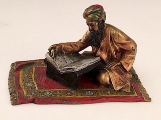 Antique vienna bronze of a man sitting on a carpet reading.<BR>Stamped "Austria" o