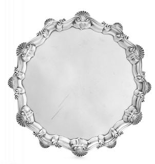A George III Silver Salver, Ebenezer Coker, London, 1761, having a rocaille and S-scroll decorated rim, raised on three volut