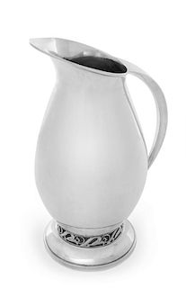 A Modernist Silver Pitcher, 20th Century, having an openwork band depicting stylized blossoms above the circular foot.