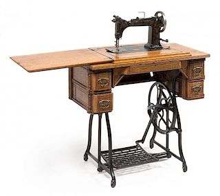 A Wheeler & Wilson Oak Treadle Sewing Machine Height 31 x width 32 x depth 16 inches (closed).