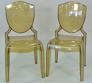 Pair of amber lucite chairs in the style of Starck Philippe having shield backs and French style legs.