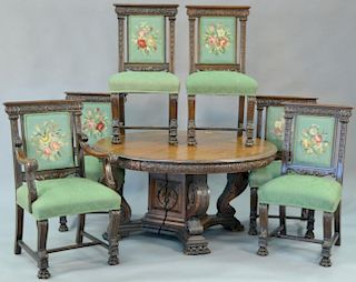 Seven piece oak dining set to include round oak table on carved pedestal base with claw feet with four 11 inch leaves and six