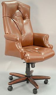 Cabot Wrenn tufted leather armchair having high back and a swivel base.