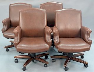 Set of four Cabot Wrenn leather armchairs having swivel bases.