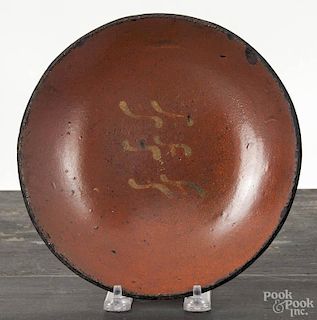Pennsylvania redware plate, early 19th c., with slip decorated wavy lines, 8'' dia.