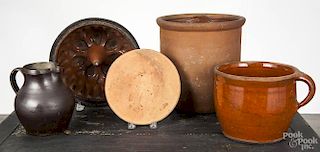 Five pieces of Pennsylvania redware, 19th c., to include a crock, a food mold, a hot plate, a milk p