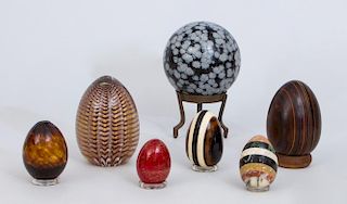 THREE GLASS EGGS, AN INLAID MARBLE EGG, A WOOD EGG, A MARBLEIZED EGG AND A DOTTED EGG