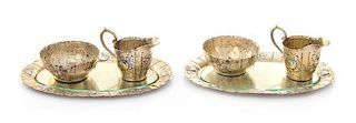 * A Pair of German Silver-Gilt Creamer and Sugar Sets, , comprising a creamer, sugar and underplate, each having floral and f
