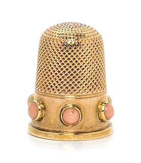 * An English Yellow Gold and Coral Thimble, , the knurled top and body above a plain band inset with six coral cabochons.