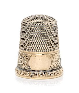 * An American 14-Karat Gold Thimble, Simons Bros., Philadelphia, PA, the knurled top and body above a volute decorated band w
