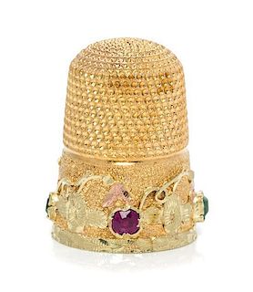 * An American Gold and Gemstone Thimble, , the knurled top and body above a floral and foliate band inset with two rubies and
