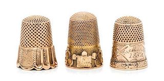 * Three Yellow Gold Thimbles, , each having a knurled top and body, one example with a trefoil decorated band to the base, on