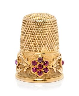 * A Continental Yellow Gold and Ruby Thimble, , the knurled top and body surmounting a floral and foliate decorated band, the
