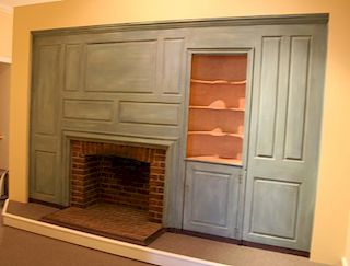 Raised panel wall having fireplace cut-out and built-in cupboard with open top and door in base, circa 1790.  ht. 93in., lg. 