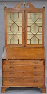 Walnut secretary desk in two parts, upper portion with broken arch top over two glazed doors on lower portion with slant lid 