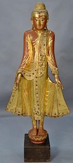 Life size Southeast Asian carved gilt and red lacquered figure of a Buddha dressed in stylized gilt and jeweled robe with elo